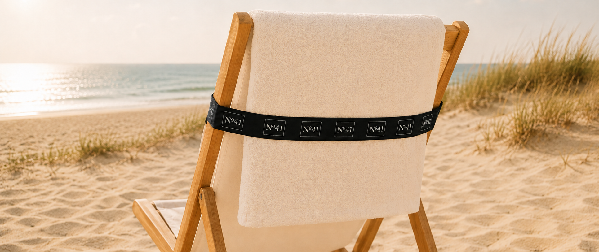BUCKLE 2-in-1 badlaken op een strandstoel aan zee